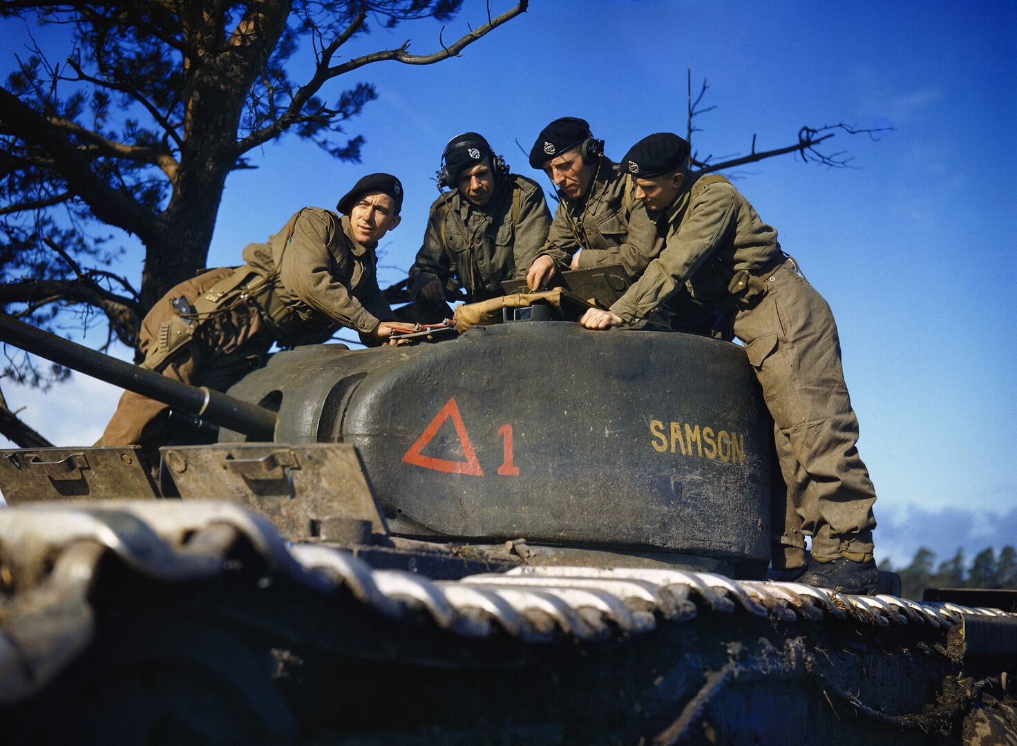 Four British tank crewmen on a Churchill Mk II turret study a map during manoeuvres at Brockenhurst, 1942